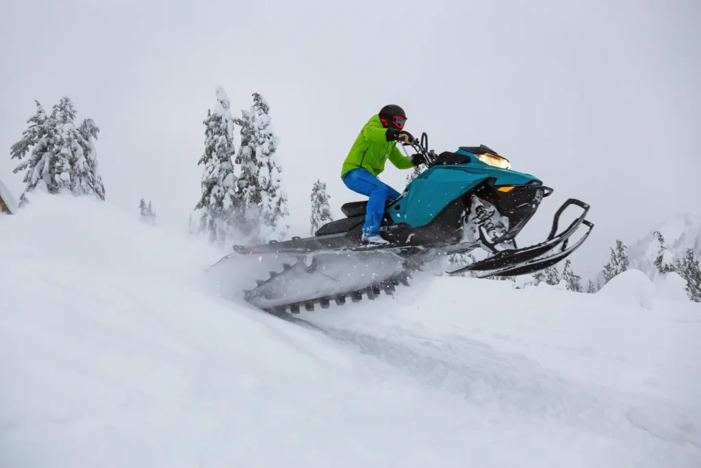 Person jumping snowmobile