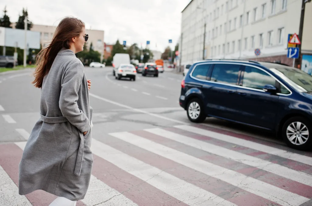 woman in gray coat crossing the street