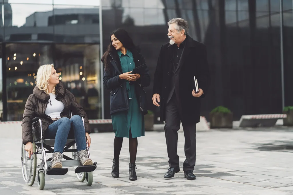 Woman in wheelchair with coworkers outside