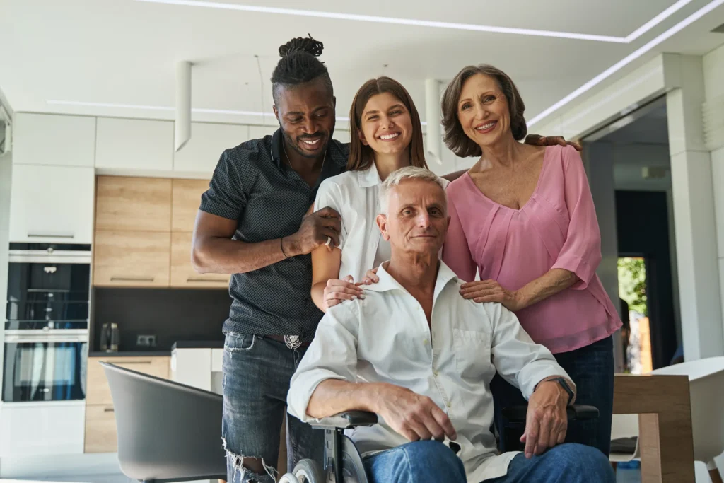Family and dad in wheelchair smiling for camera