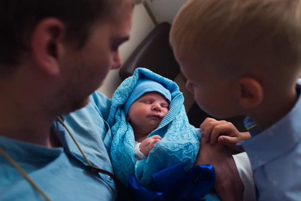 Newborn baby in the hands of father